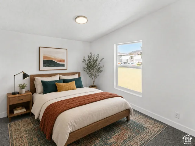 Recessed lighting, wood-finish bed frame, wood-finish nightstand with storage, white walls, and a window with natural light