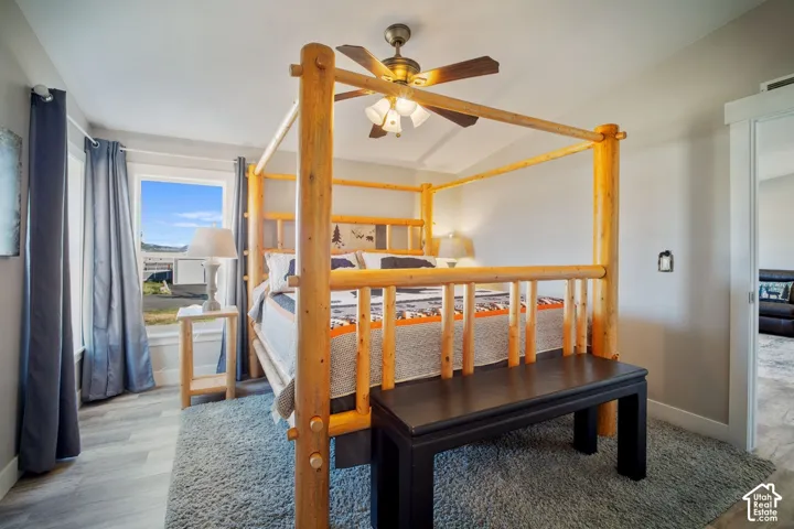 Room featuring wood-finish flooring, a ceiling fan with integrated lighting, and a window with natural light