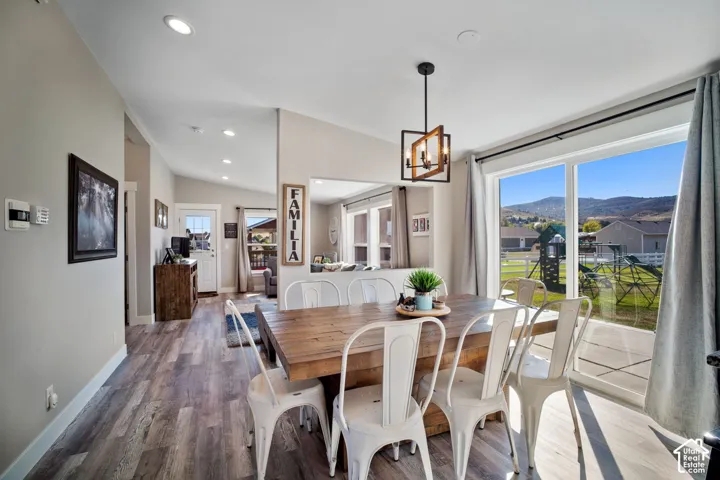 Vaulted ceilings with recessed lighting, wood-finish flooring, and a contemporary chandelier