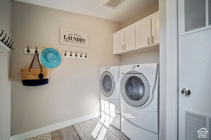 White shaker-style cabinetry with silver hardware, wood-finish flooring, and white baseboards