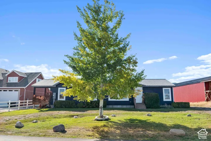 Single-story property featuring a metal roof, dark exterior siding, and white trim windows