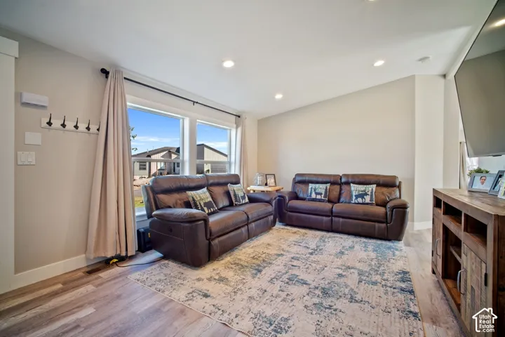 Recessed lighting illuminates the wood-finish flooring
