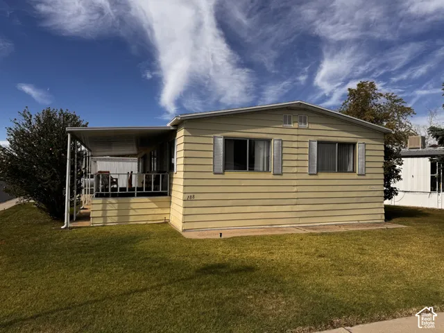 Exterior featuring horizontal siding, multiple windows with louvered shutters, and a covered front porch with railings