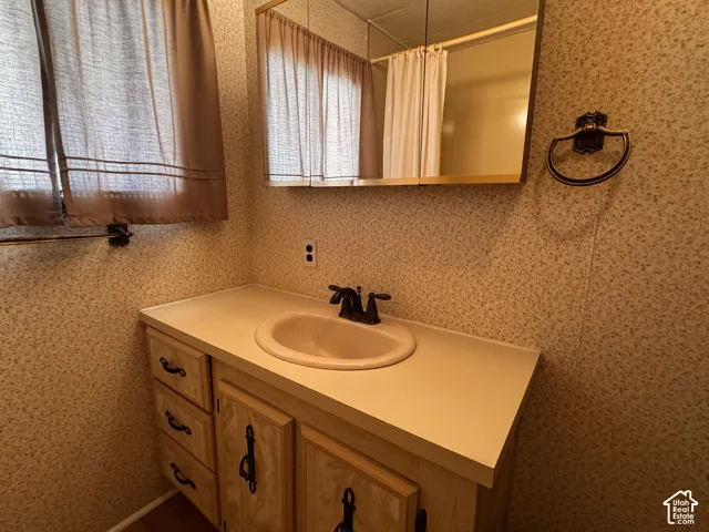 Vanity with integrated sink, bronze-finish faucet, and coordinating hardware