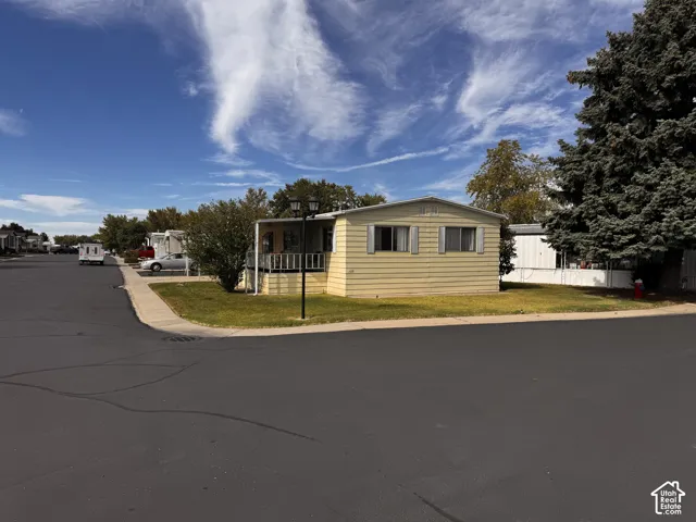 Yellow siding exterior with white window shutters