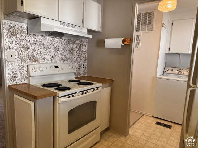 Kitchen area featuring white cabinetry, a white electric range, and a patterned backsplash