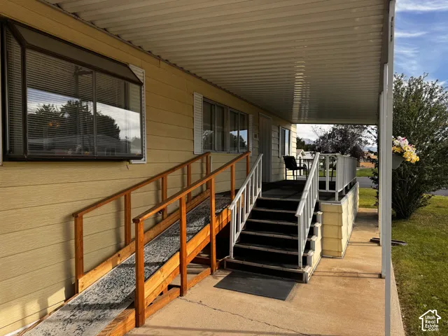 Covered porch entry featuring a wood-framed ramp and separate staircase