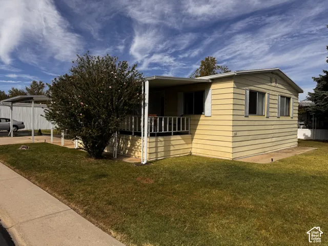 Exterior featuring horizontal siding, covered porch, and a metal carport