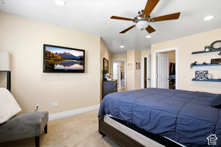 Recessed ceiling lighting, ceiling fan with integrated light, wall-mounted shelving, and paneled interior doors