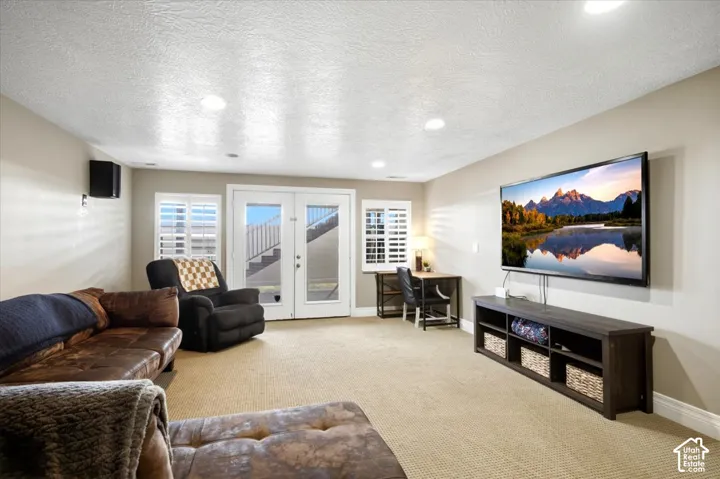 Recessed lighting, light-toned carpeting, neutral wall paint, white double French doors, and white window shutters