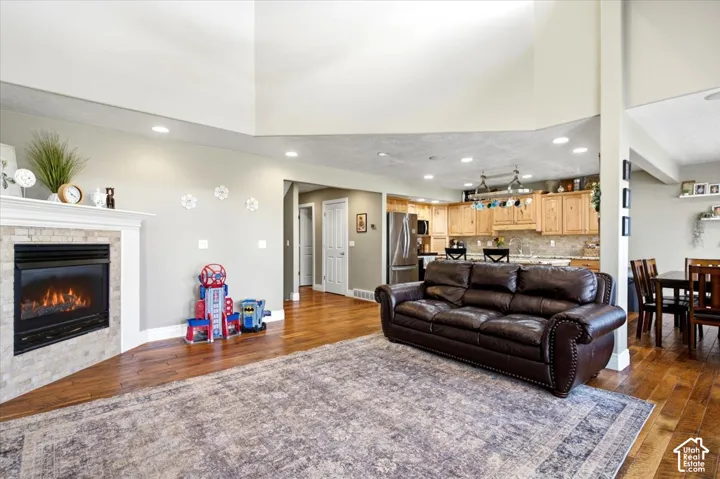 Hardwood-finish flooring throughout, featuring a fireplace with a stone surround and mantel