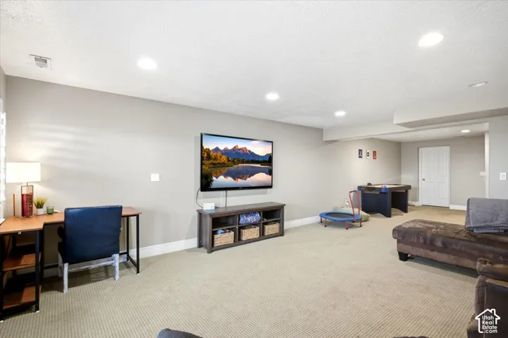 Recessed lighting, light gray wall paint, white trim, and light beige carpet