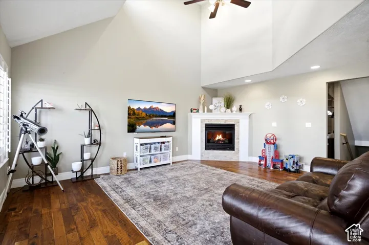 Vaulted ceilings, wood-finish flooring, recessed lighting, fireplace with a mantel, and shuttered windows