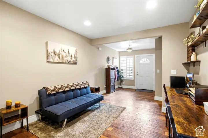 Entryway with wood-finish flooring, recessed lighting, and a white paneled door with louvered side panels