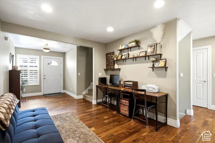 Hardwood flooring, recessed lighting, built-in shelving, white paneled doors, and a white front entry door with a decorative glass insert