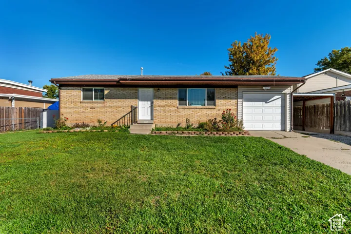 Brick exterior with a brown shingle roof, attached garage, and a concrete driveway
