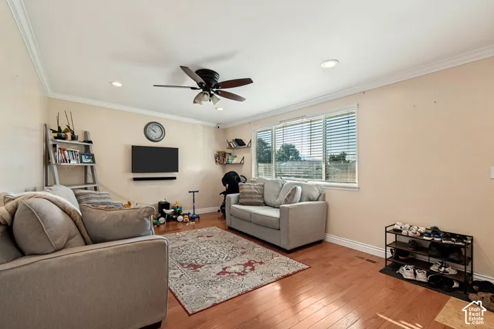 Wood-finish flooring, recessed lighting, crown molding, and a ceiling fan with integrated lighting