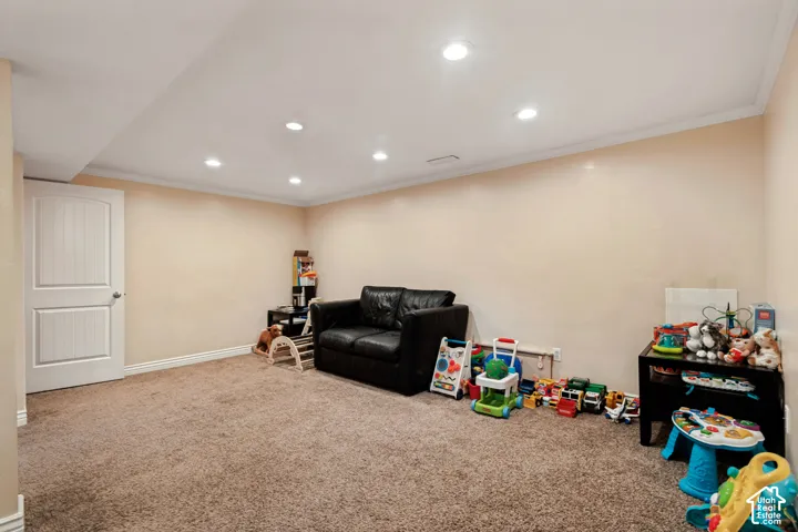 Recessed lighting, crown molding, and neutral wall paint
