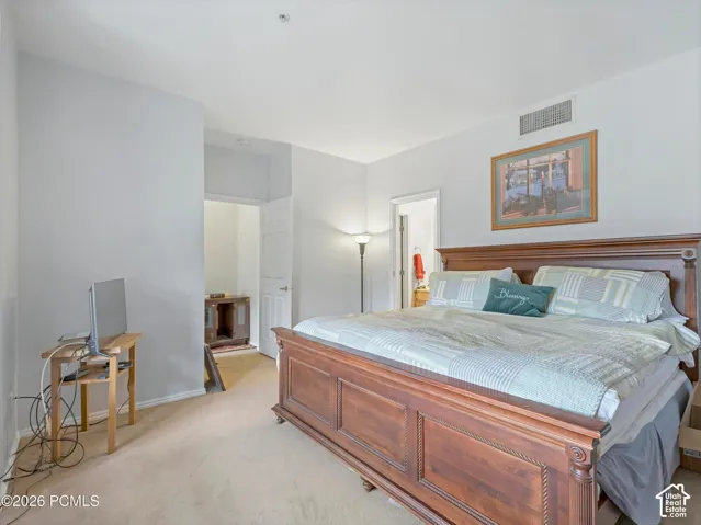 Carpeted flooring, white painted walls, and an overhead ventilation system