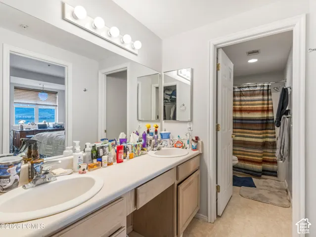 Dual vanity with integrated sinks, recessed lighting, and a six-bulb light fixture