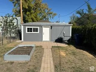 Detached outbuilding with gray siding and white trim