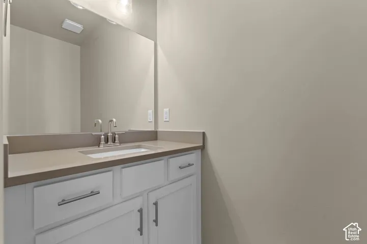 Vanity with a light-toned countertop, undermount sink, and brushed nickel faucet