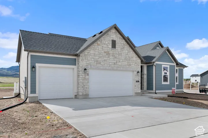 Stone and siding exterior with a two-car garage and additional single-car garage