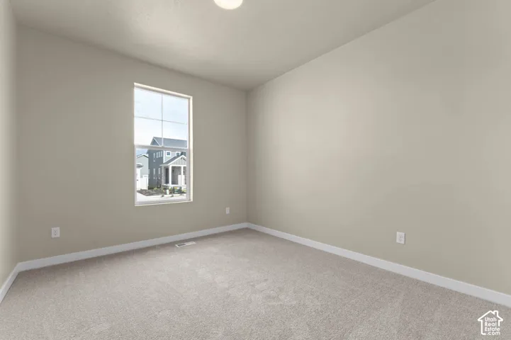 Neutral wall finishes, light-colored carpeting, and a large window with grid pattern
