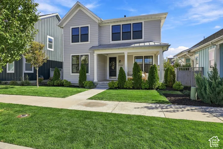 Modern farmhouse exterior with clean white, concrete-board siding, pitched roofline, and multi-pane windows