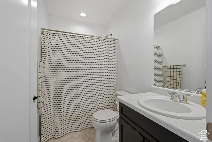 White vanity quartz countertop with integrated sink, dark wood-finish cabinetry, and chrome fixtures