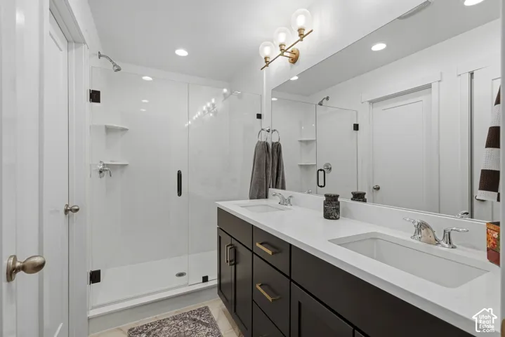 Primary Bath Suite with dual sink vanity, integrated sinks and dark wood-finish cabinetry