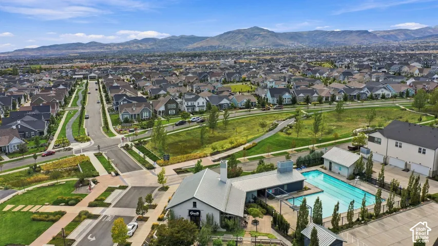 Community pool with adjacent clubhouse, restaurant and surrounding green space, integrated within the residential neighborhood