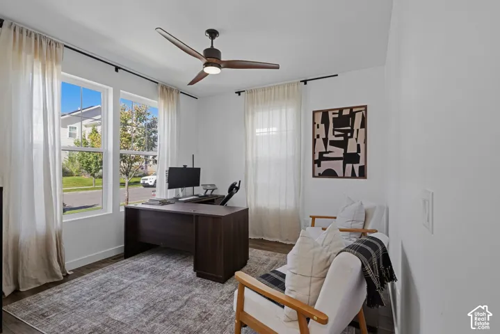 Entryway-handy Home Office with bright interior, large windows, wood-flooring, a contemporary ceiling fan, and crisp white walls