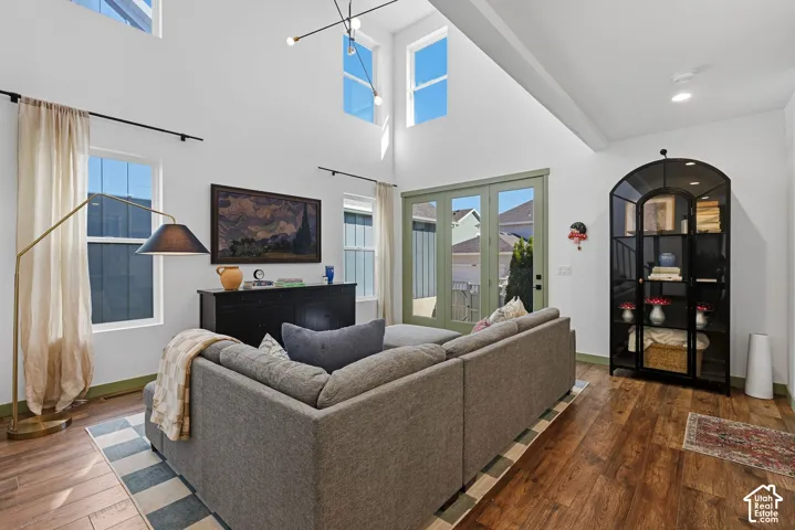Vaulted ceilings with clerestory windows, wood-finish flooring, recessed lighting, and double glass doors