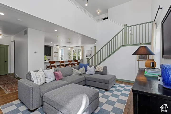 Open-concept living area with high ceilings, plentiful natural light, recessed lighting, and wood-finish flooring