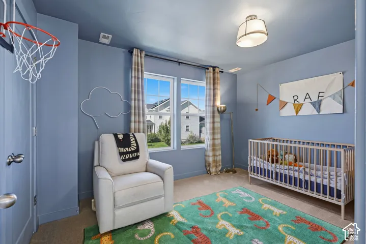 Dual windows with exterior views, overhead semi-flush mount light fixture, wall-mounted light fixture, and neutral carpet flooring