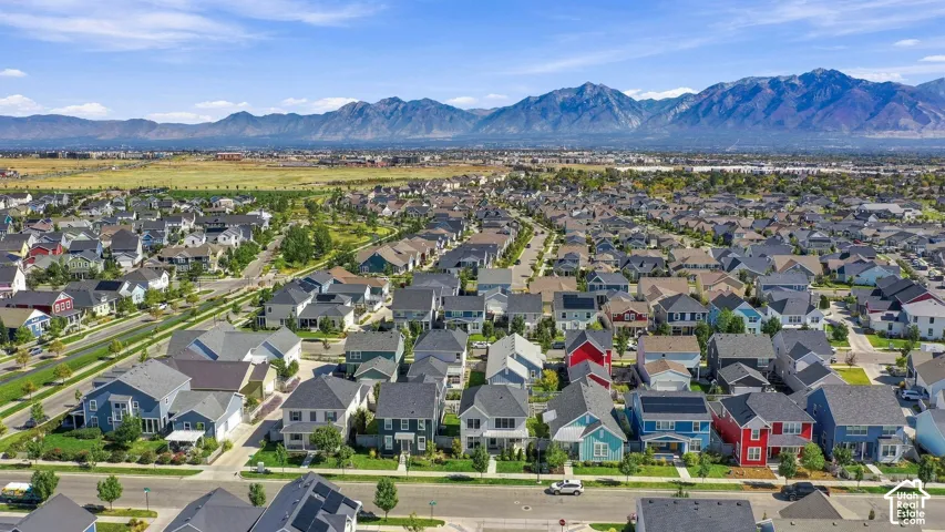 Residential community with varied architectural styles and mature street trees, set against a backdrop of distant mountains