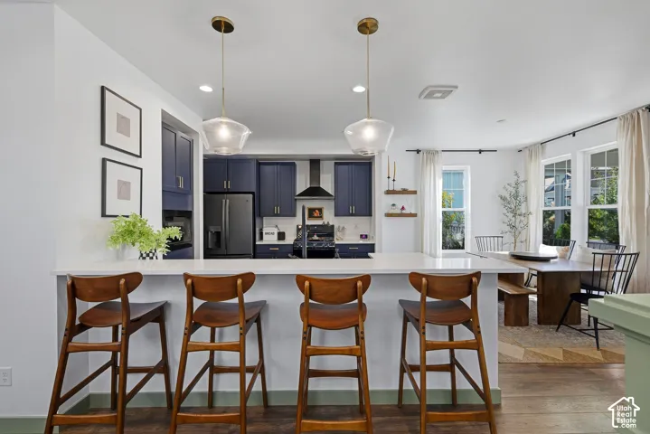 Kitchen island with a white quartz countertop and brass-finish pendant lighting