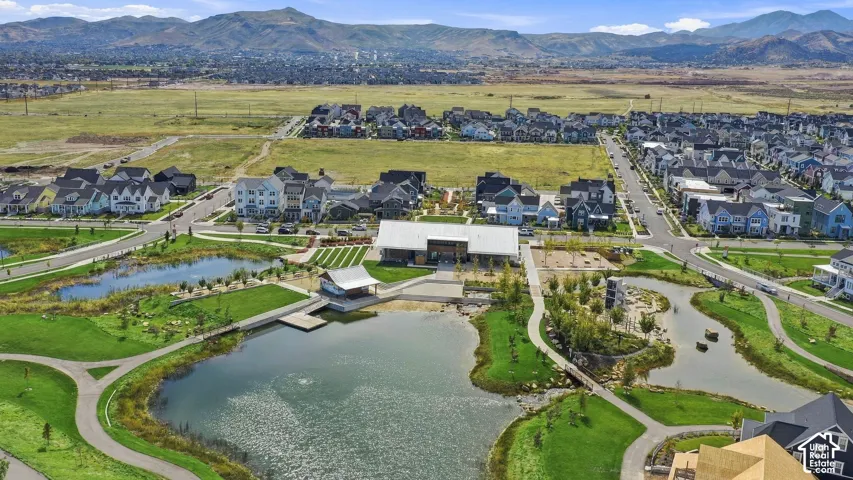 Expansive large pond, extensive green spaces, paved pathways, and mountain scenery