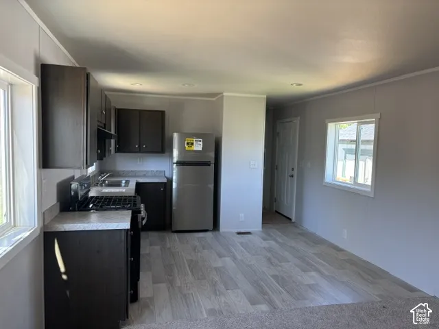 Well-appointed kitchen featuring dark wood-finish cabinetry, stainless steel appliances, and wood-finish flooring