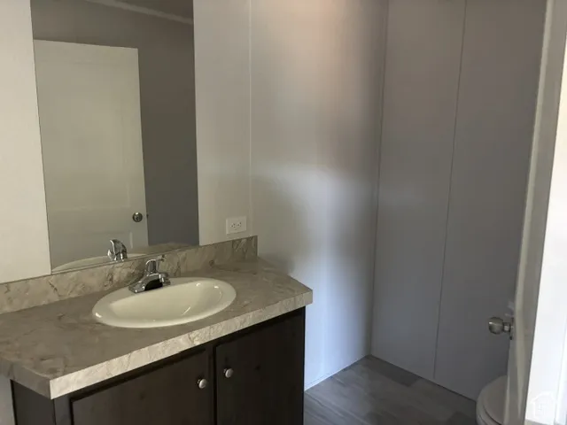Vanity with an oval undermount sink, chrome faucet, and integrated backsplash
