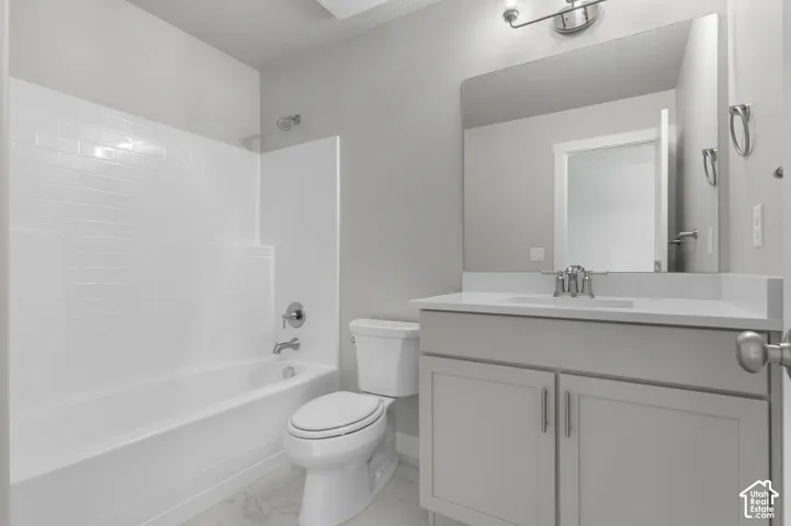 Bathroom featuring a tub/shower combination with white subway tile surround, a single vanity with stone-finish countertop, and wood-finish flooring