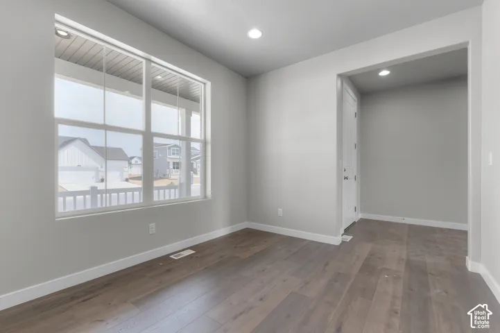 Expansive window with white gridded panes, wood-finish flooring, recessed ceiling lighting, and a paneled interior door