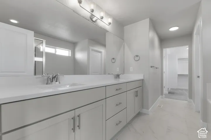 Dual vanity with white countertops, undermount sinks, and chrome-finish faucets