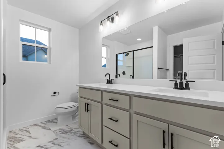 Dual vanity with white countertops, matte black fixtures, and light cabinetry