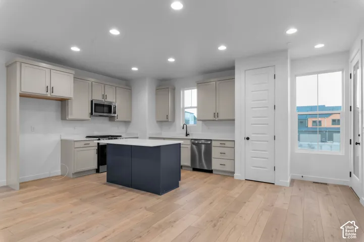 Kitchen with light wood-finish flooring, recessed lighting, and white walls