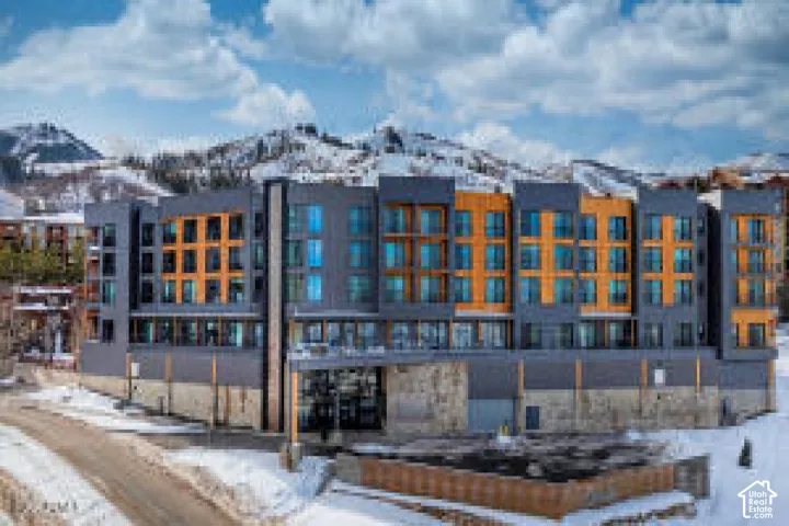 Contemporary multi-story building featuring a facade of dark paneling and natural wood-finish accents