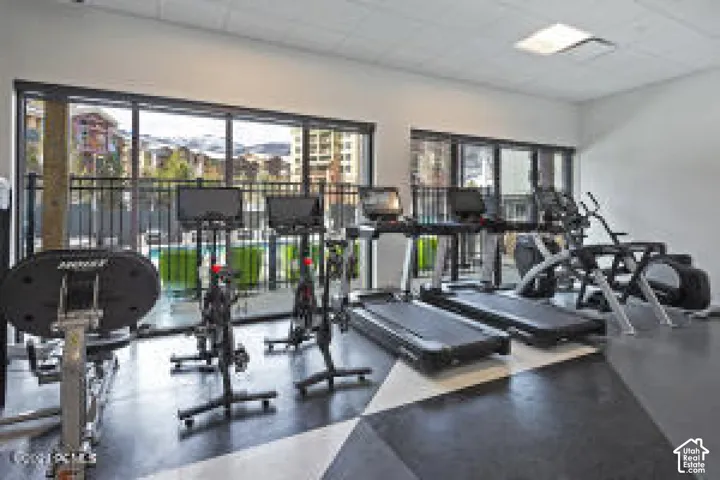 Fitness center featuring dark flooring with a geometric pattern, extensive window lines, and recessed lighting