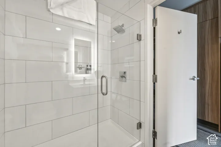 Shower enclosure featuring clear glass panels and a chrome handle