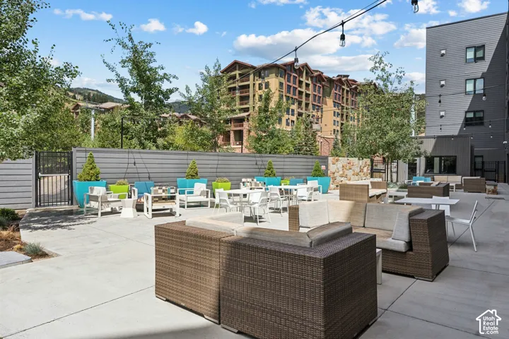 Spacious outdoor patio with string lights, concrete pavers, and a stone accent wall
